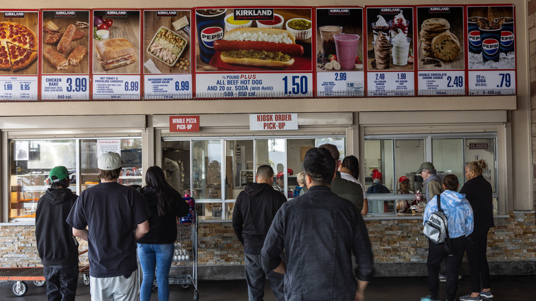 People wait in line at the food court at a Costco warehouse