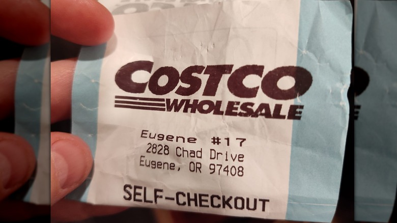 A close-up of someone holding a Costco self-checkout receipt