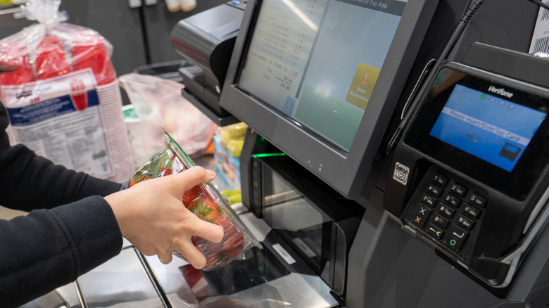 A customer using the self checkout lane in a Costco store