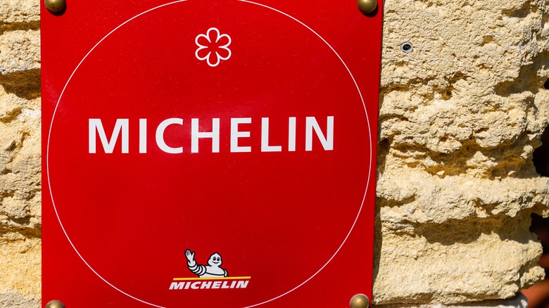 Red sign with michelin star logo and text.