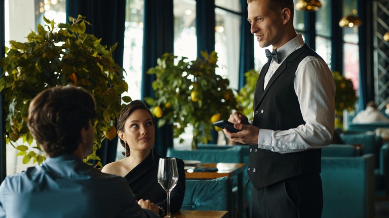 waiter takes order at formal restaurant