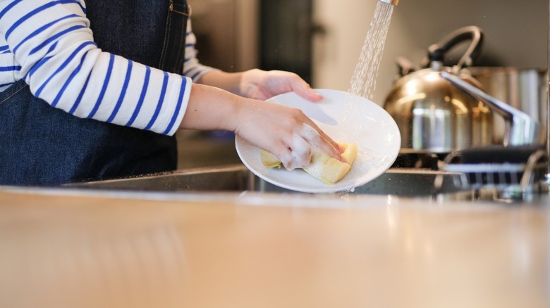 hand-washing dishes in a sink