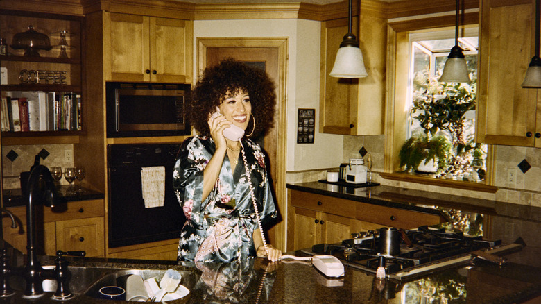 Woman on phone in 1980s-style kitchen