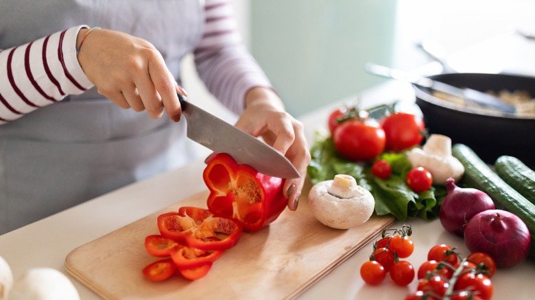 woman chopping vegetables on cutting board