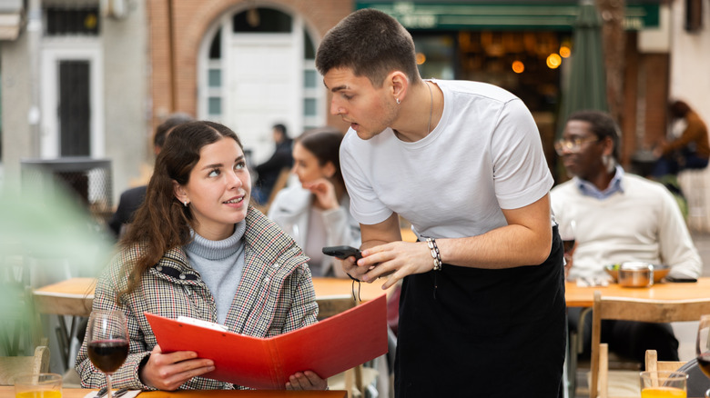A waiter in a restaurant taking someone's order