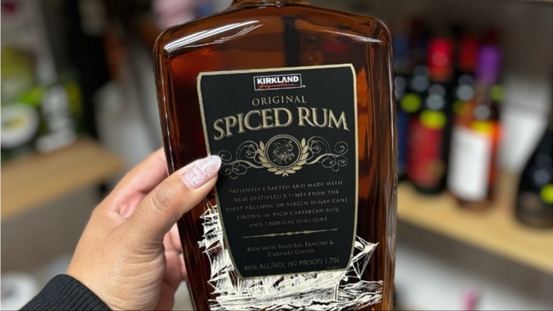 Costco spiced rum in hand held against store display