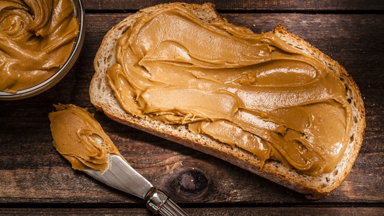 peanut butter spread on bitten toast