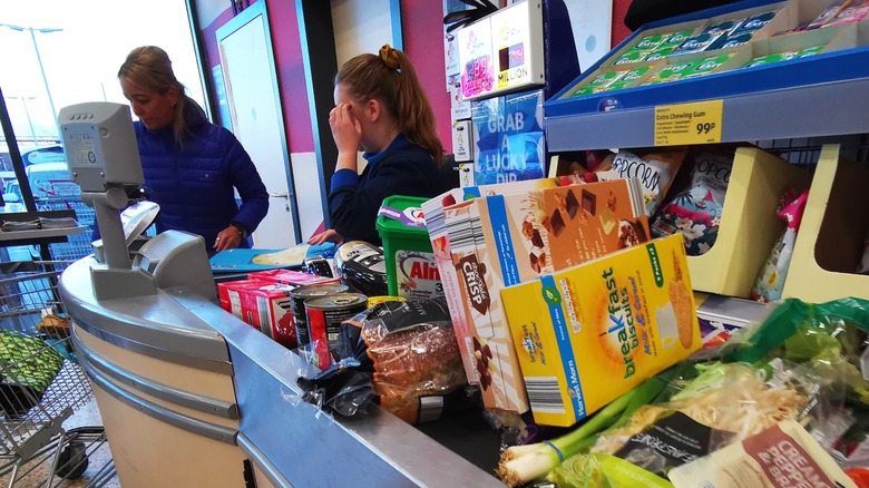 Items on conveyor belt at Aldi with cashier in background