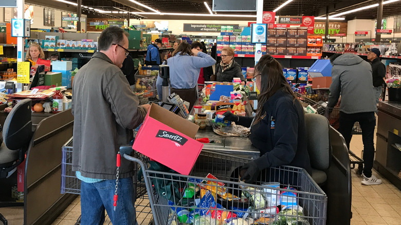 Cashier ringing up items for customer at Aldi