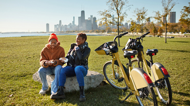 Two people eat with chicago cityscape in background.