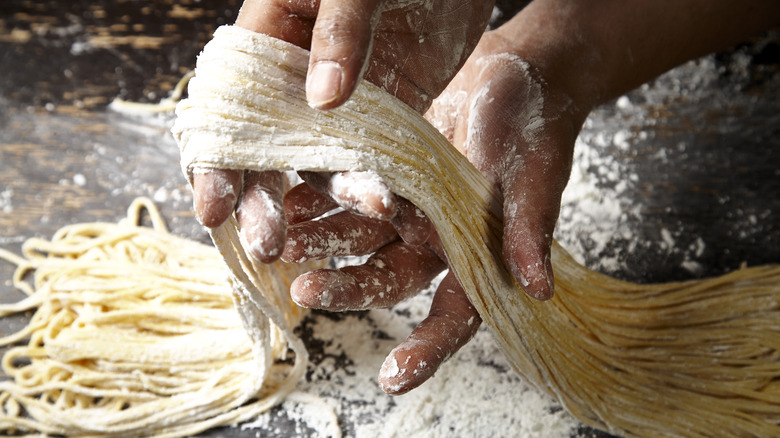 person making pasta by hand