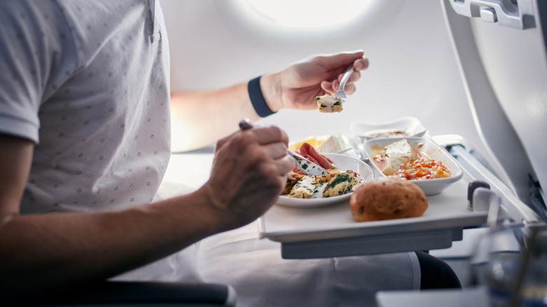 person eating food on plane