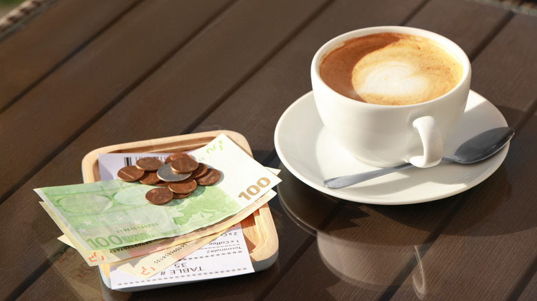 Bill and change in Euros with coffee cup on a table