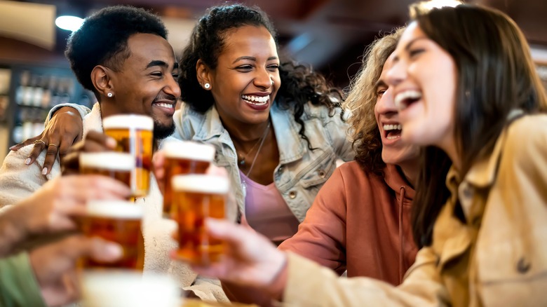 A group of diners with beers toasting one another