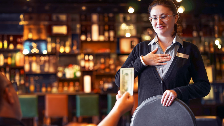 Restaurant server gratefully accepting tip