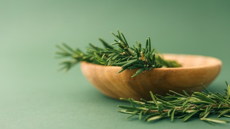 freshly cut rosemary in wooden bowl
