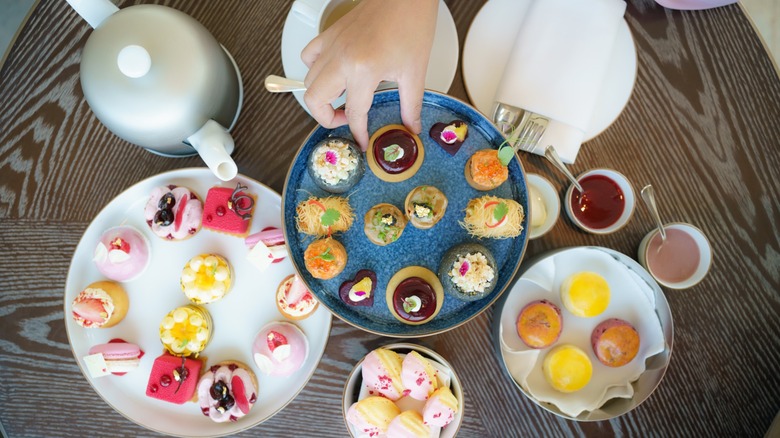 a hand picks up finger food at afternoon tea