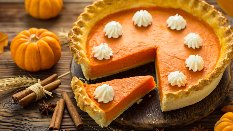 Sliced pumpkin pie with dollops of whipped cream.