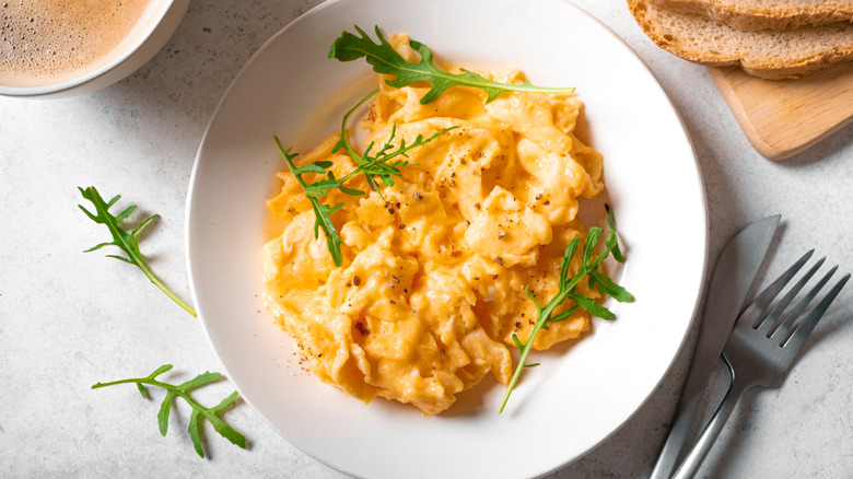 Fluffy scrambled eggs on white plate