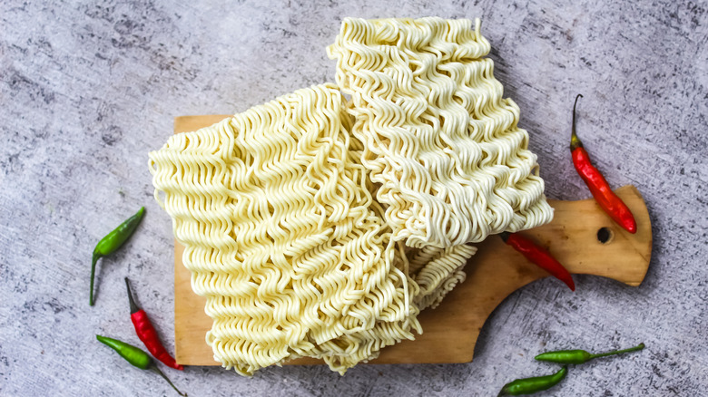 Dried instant ramen on cutting board.