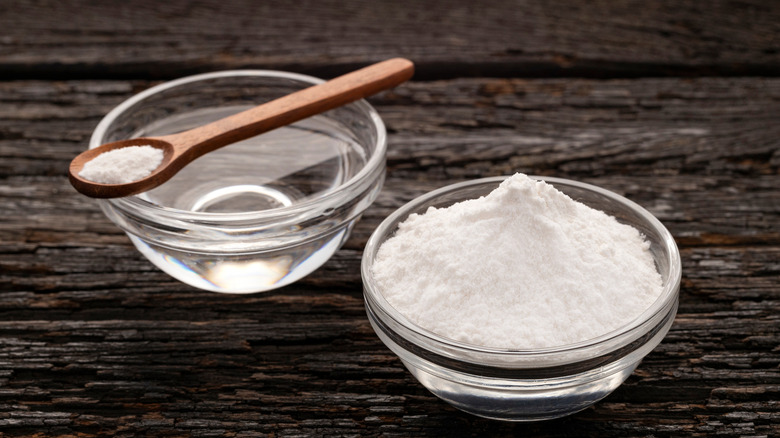 Glass bowls of baking powder and water on tabletop