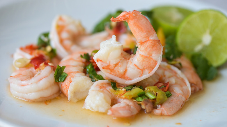 fresh shrimp on white plate with vegetables and lime
