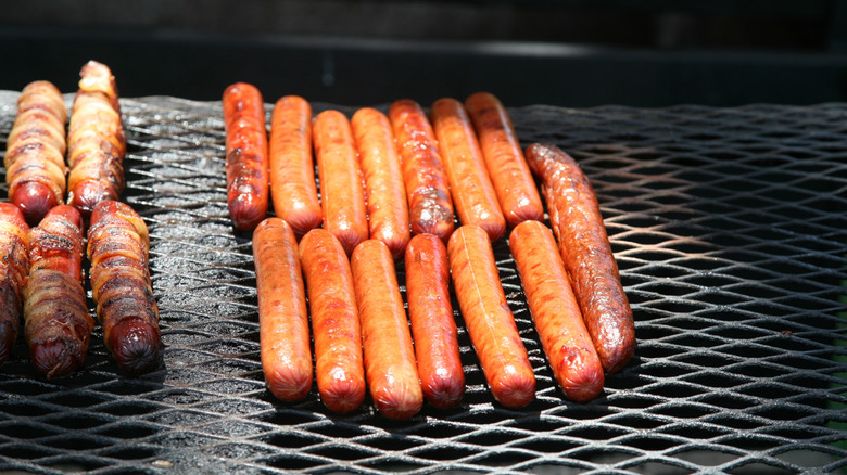 Many hot dogs cooking on grill grate