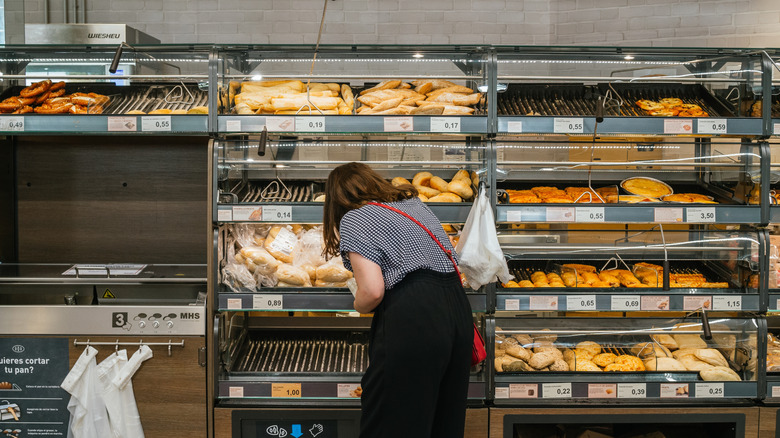 Woman shopping in Aldi bread bakery section.