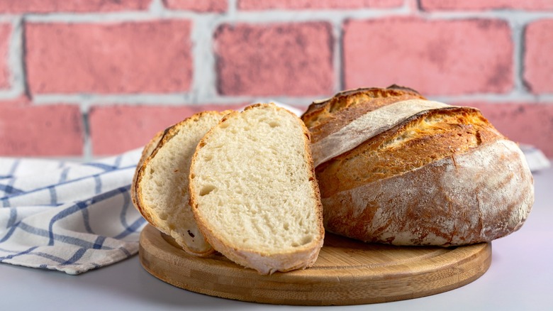 sourdough loaf with slices on dish towel