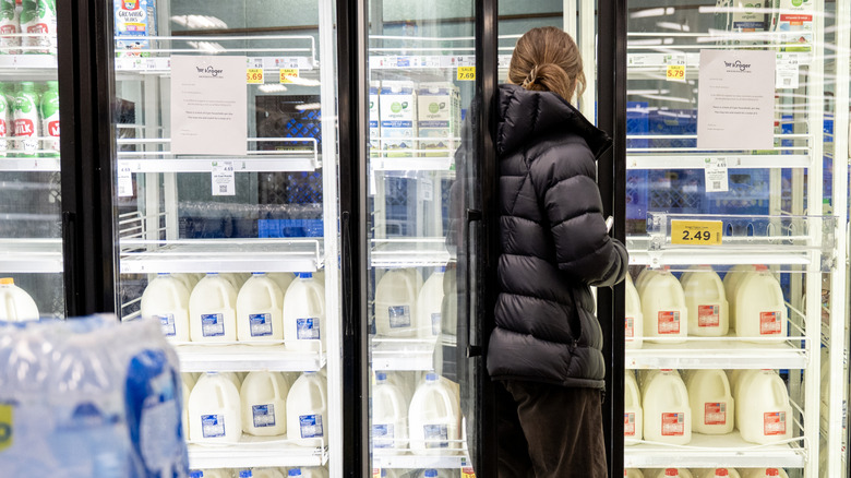 Customer buying gallon jugs of milk at Kroger.