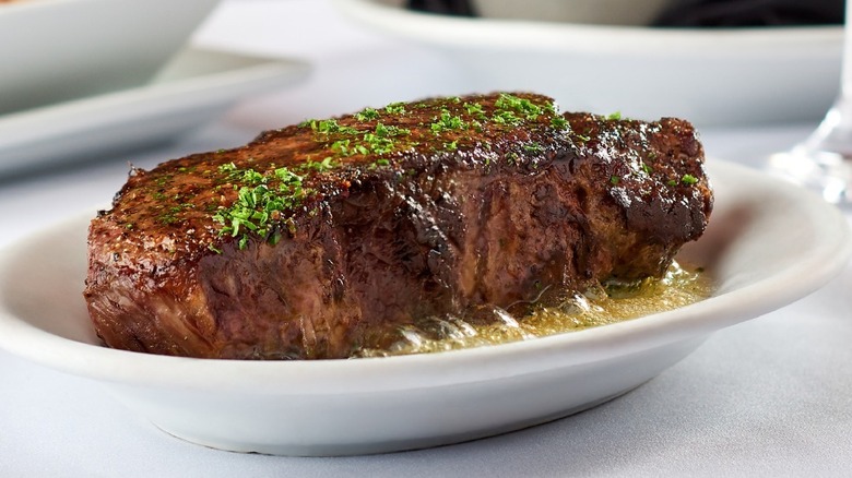 Closeup of New York strip steak on white dish, Ruth's Chris Steak House