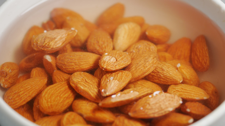 A close-up of almonds soaking in a small bowl of water