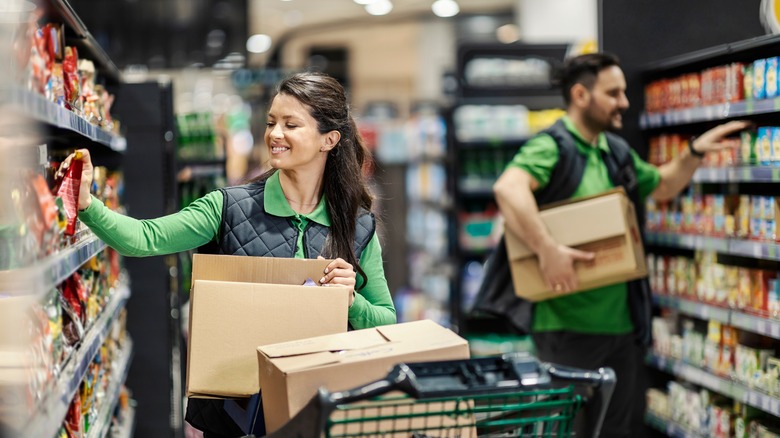 Supermarket employees stocking shelves