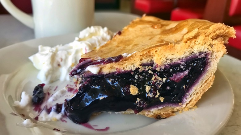 slice of blueberry pie and whipped cream on plate