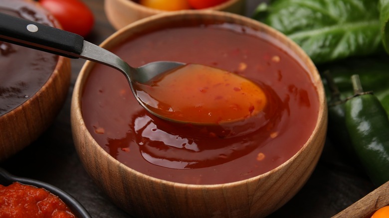 Spoon lifting marinade out of wood bowl