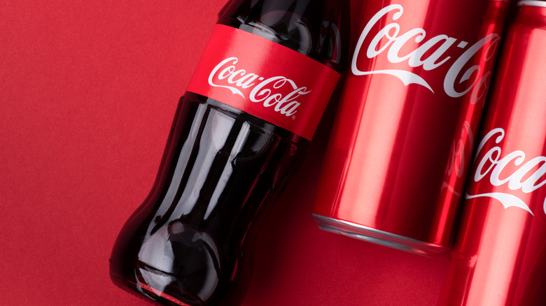 bottle of coca-cola next to can of coca-cola