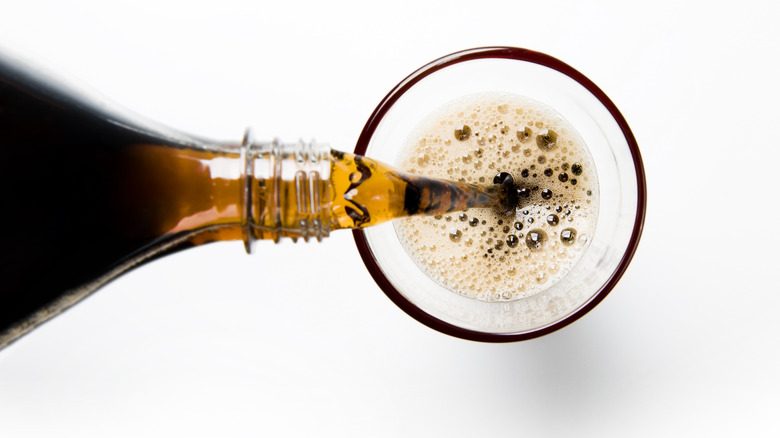 pouring coke into a glass filled with ice