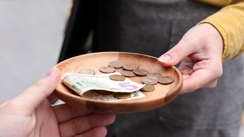 Person passing money on tray