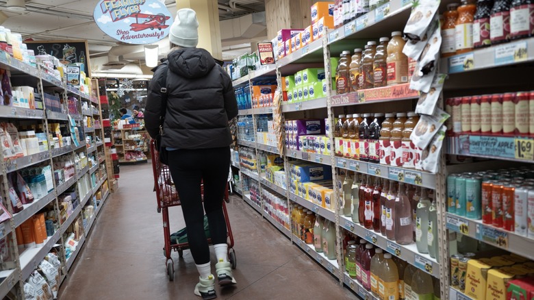 customer pushes shopping cart in trader joe's