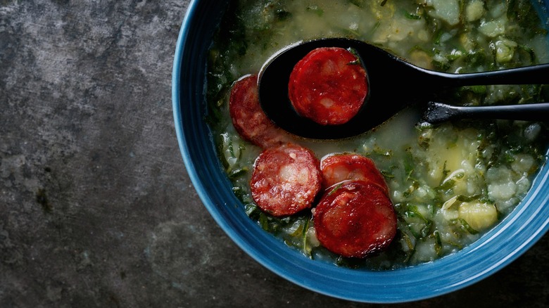 a bowl of kale soup features cooked chourico