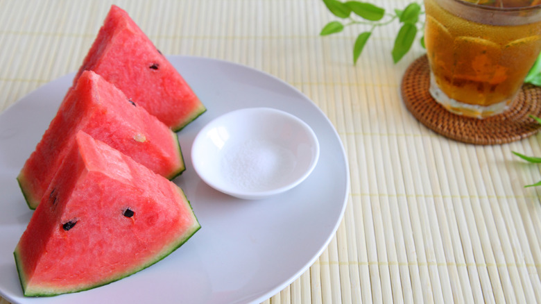 sliced watermelon alongside small bowl of salt