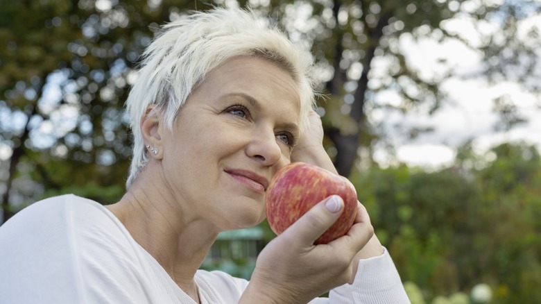 woman holds a red apple