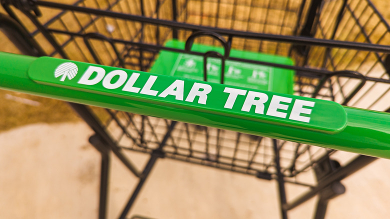 A close-up of the handle of a Dollar Tree shopping cart