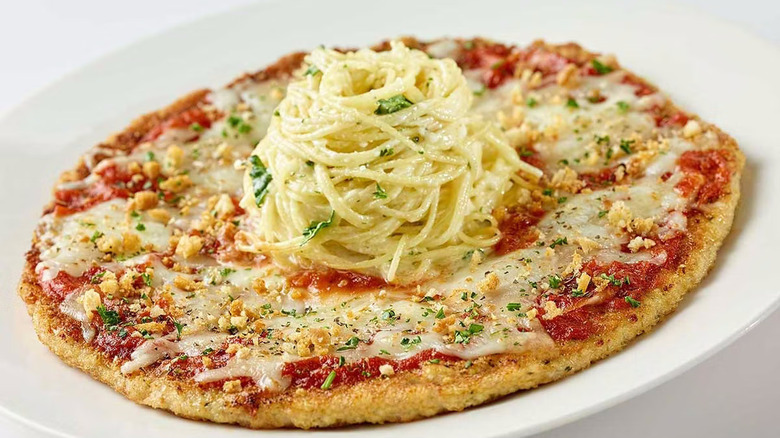 Circular chicken parmesan with pile of pasta on top