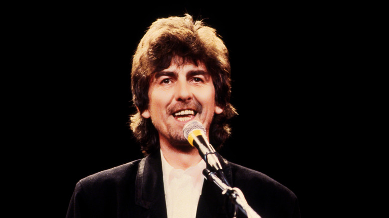 George harrison on stage with microphone