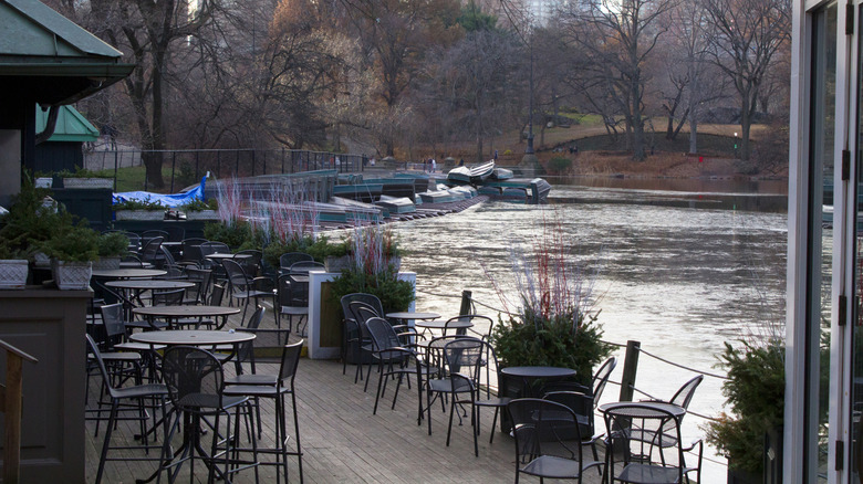 Central Park Boathouse outdoor dining area with boats in the background.
