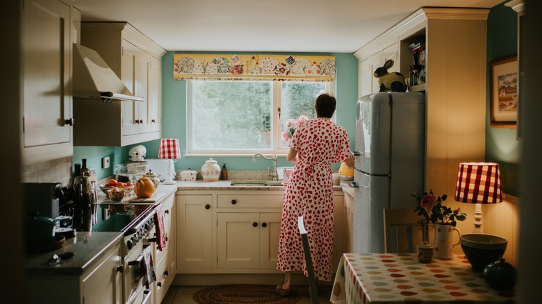 a woman's back is seen in a vintage kitchen
