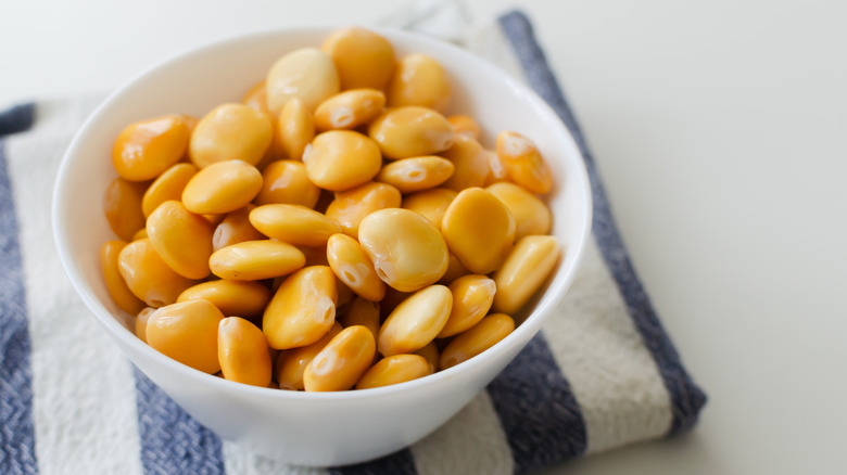 Lupin beans in a white bowl on a striped napkin