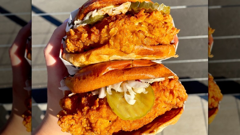 Someone holding two fried chicken sandwiches from Birdcode