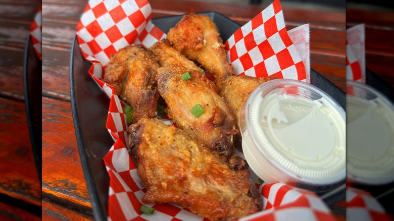 A basket of fried chicken wings and sauce from Willie's Hot Chicken